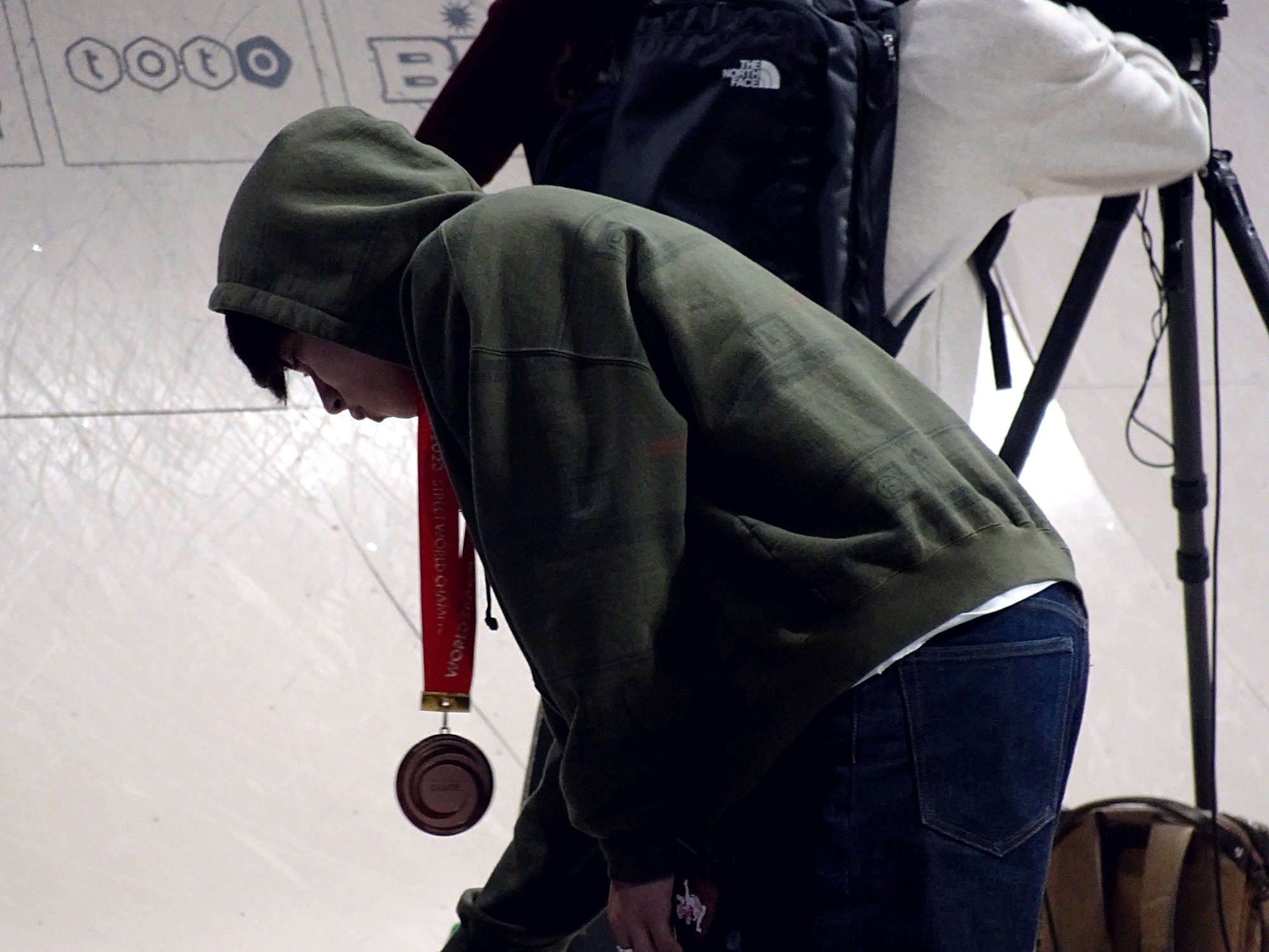 Yuto Horigome, médaille de bronze autour du cou, signe des autographes aux Mondiaux de Tokyo en 2023
