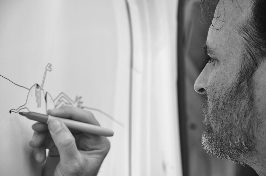 Ed Templeton dessine un de ses personnages au feutre sur la porte d'un van à Nuoro en 2010