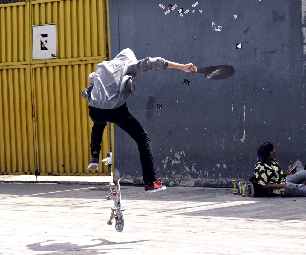 Flip trick à Mexico : la planche passe debout entre les jambes écartées du skateur