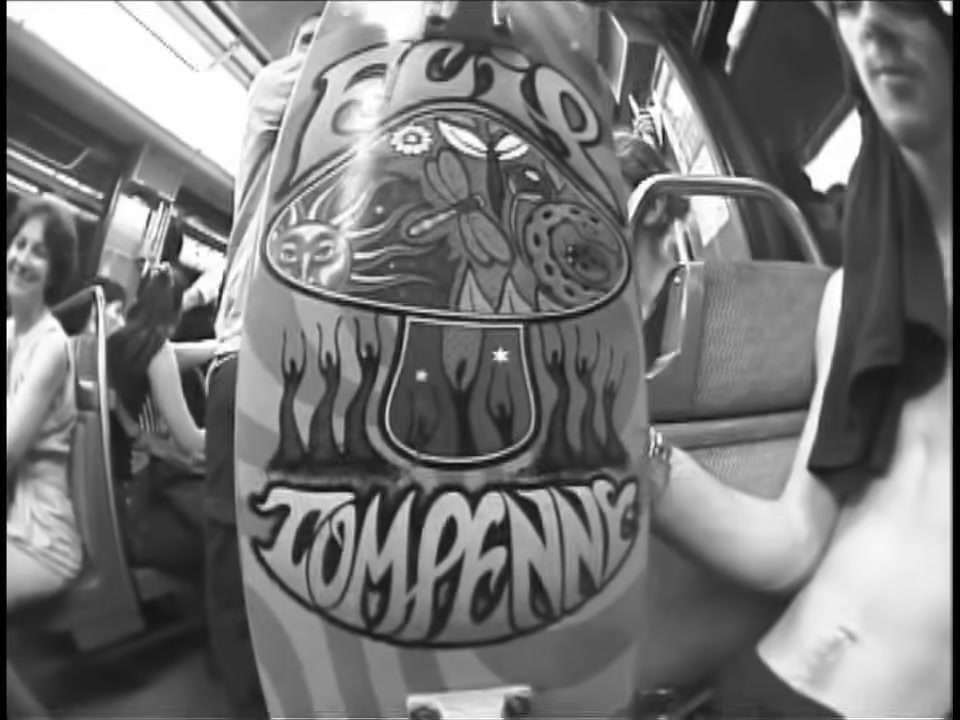 Une planche Flip au nom de Tom Penny tenue dans un bus, image de la partie Menikmati (éS, 2000)