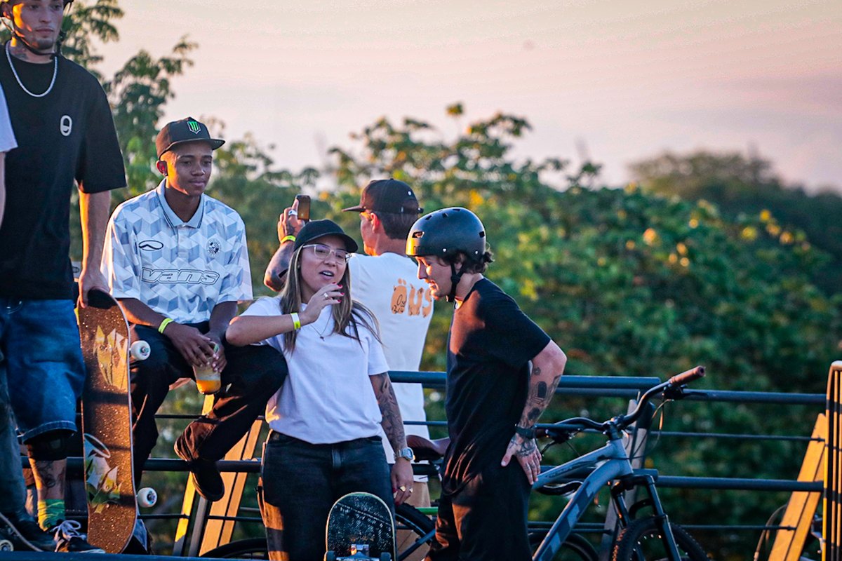 Pâmela Rosa au centre, casquette et lunettes, entourée de skateurs au bord de la piste