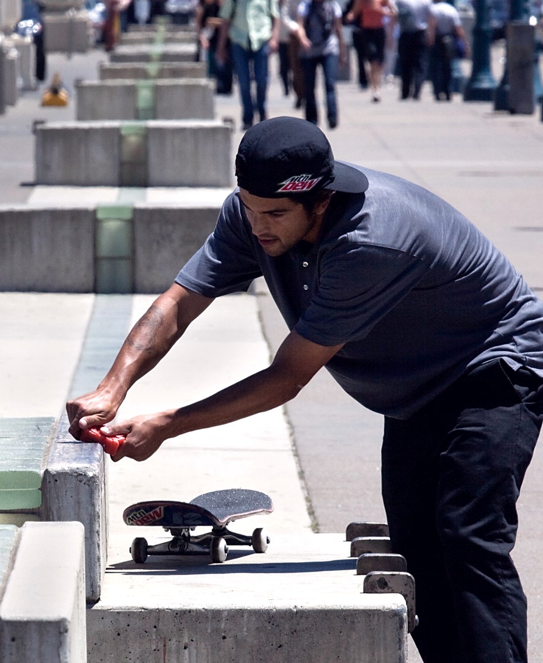 Paul Rodriguez passe le wax sur un ledge en béton à San Francisco en 2010, sa planche posée à côté