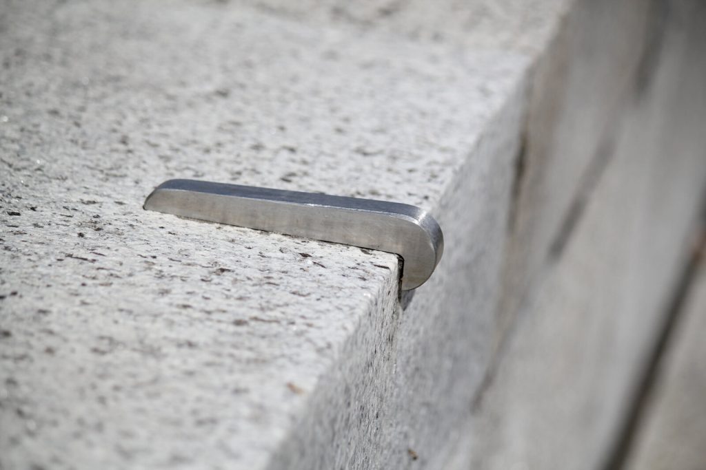 Skatestopper vissé sur un ledge en granit, la bosse métallique que la ville pose contre les skateurs