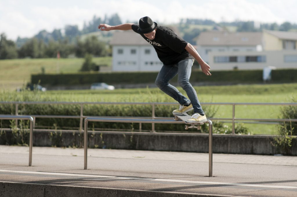 Backside Smith grind sur une barre basse : bras ouverts pour l'équilibre, poids sur le truck arrière