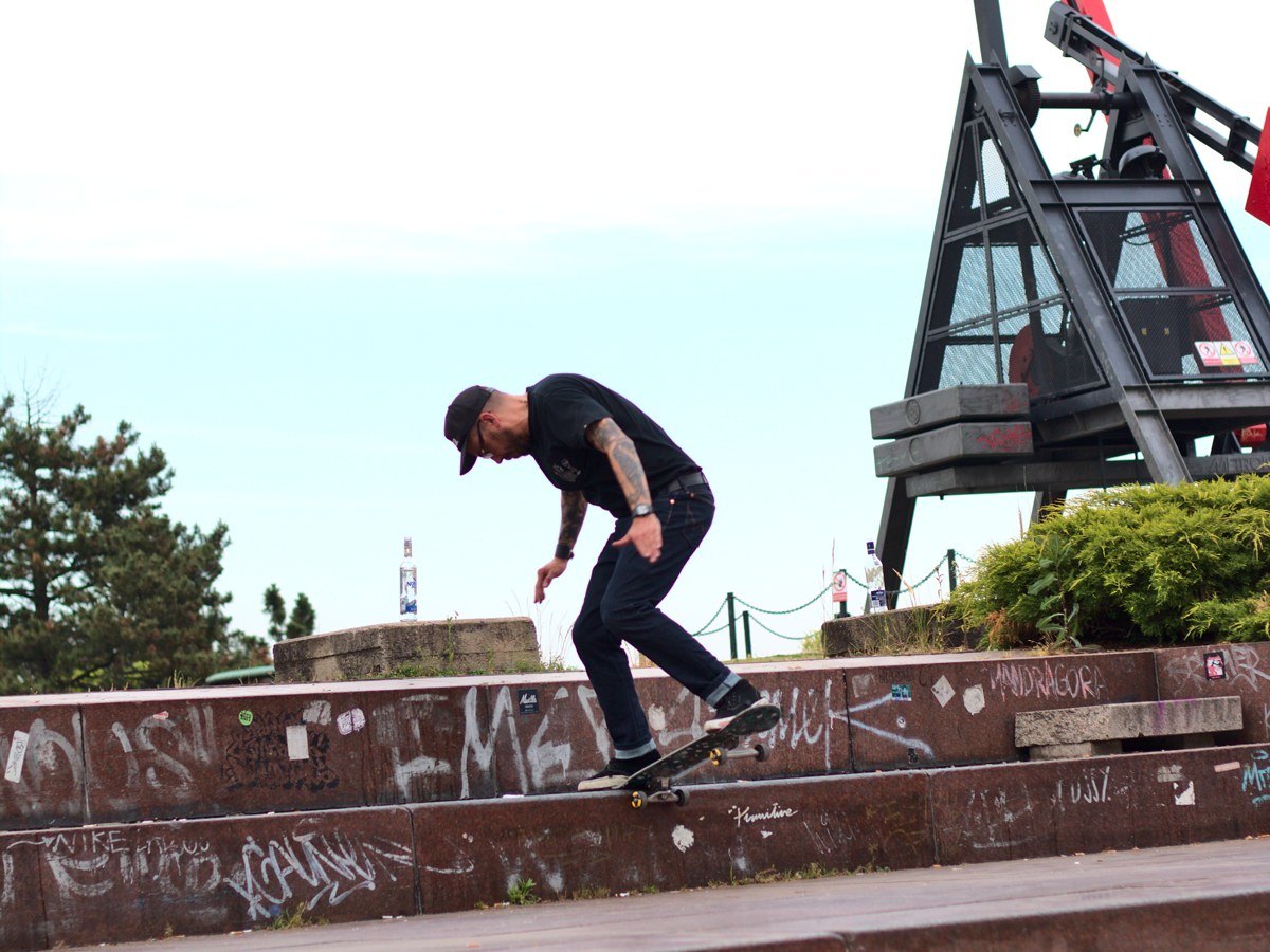 Un skateur en grind sur un ledge de granit tagué de Stalin Plaza, au pied du métronome de Letná à Prague
